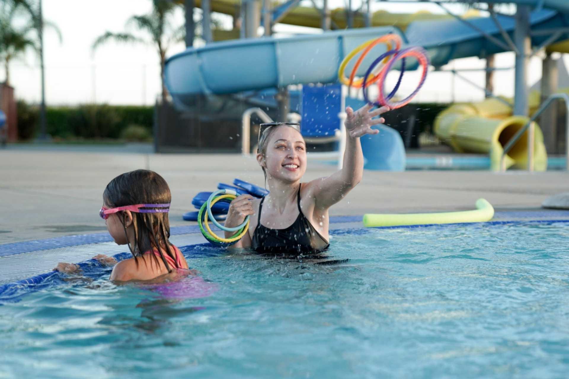 Swim instructor throwing rings for participant